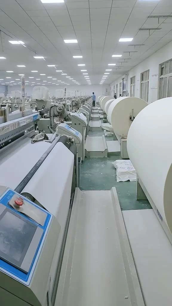 Cotton Fabric Is Being Produced Through A Mechanized Production Process. Cotton Fabric Is Being Produced Through A Mechanized Production Process.